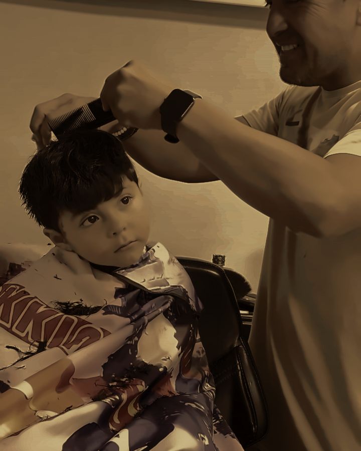Antonio cortándole el pelo a un niño con calma